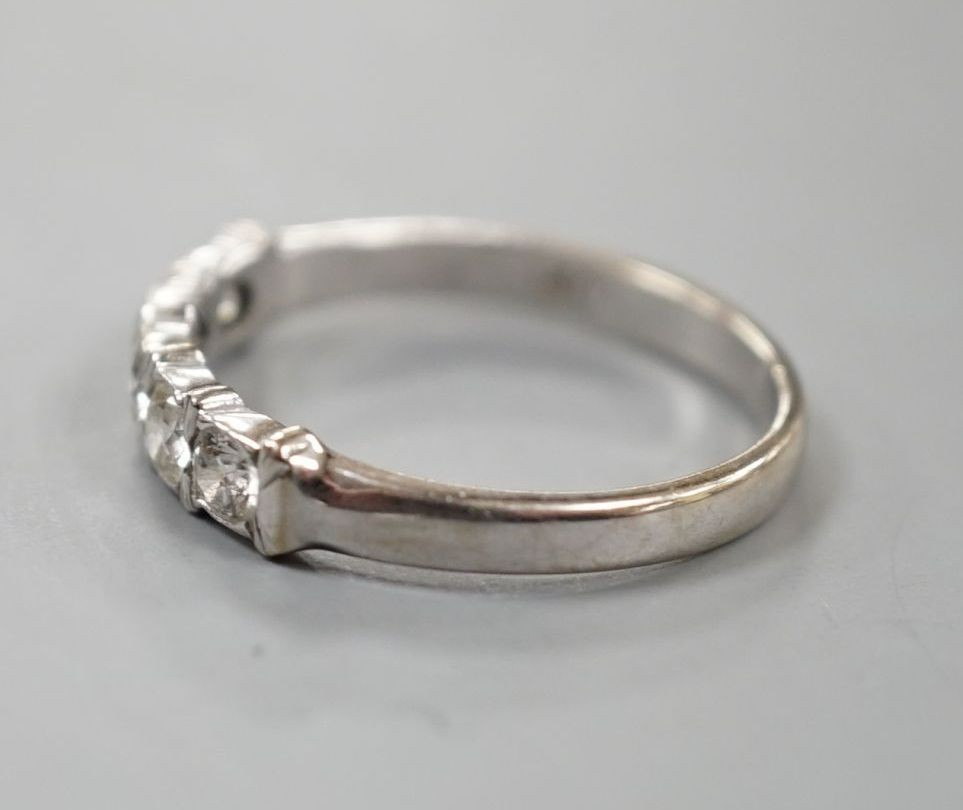 An 18ct white metal and five stone diamond set half hoop ring, size R, gross weight 3.4 grams.